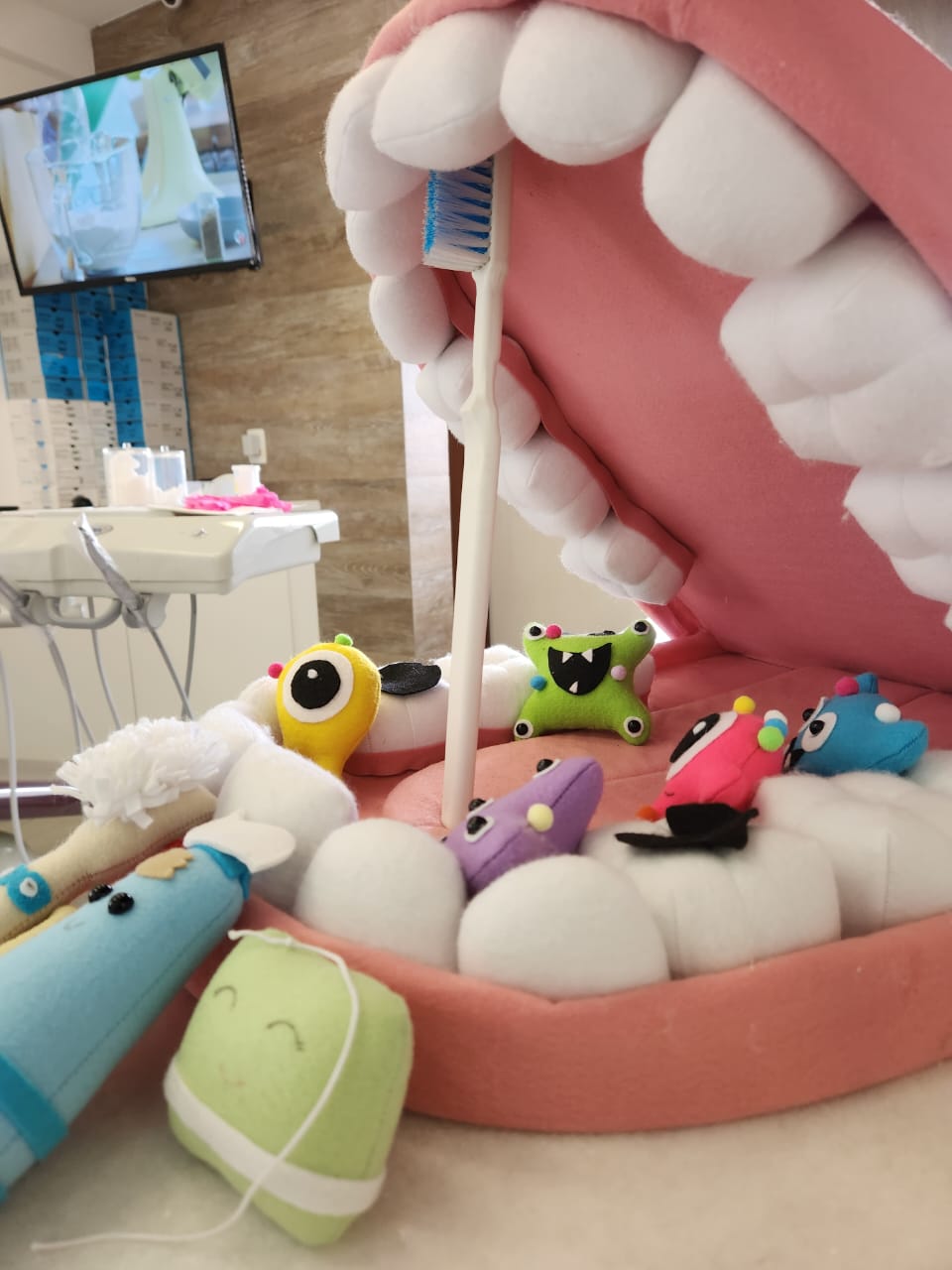 Modelo de arcada em pelúcia com escova gigante, usado nas consultas de odontopediatria com crianças e bebês